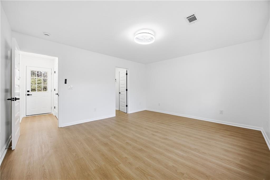 1775 Hadlock Street Southwest Atlanta, GA 30311 - Photo 22 of 27 an empty room with wooden floor and windows
