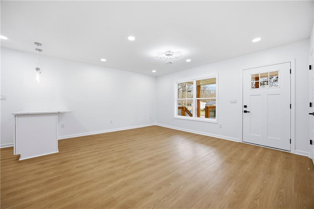 1775 Hadlock Street Southwest Atlanta, GA 30311 - Photo 4 of 27 an empty room with wooden floor and windows