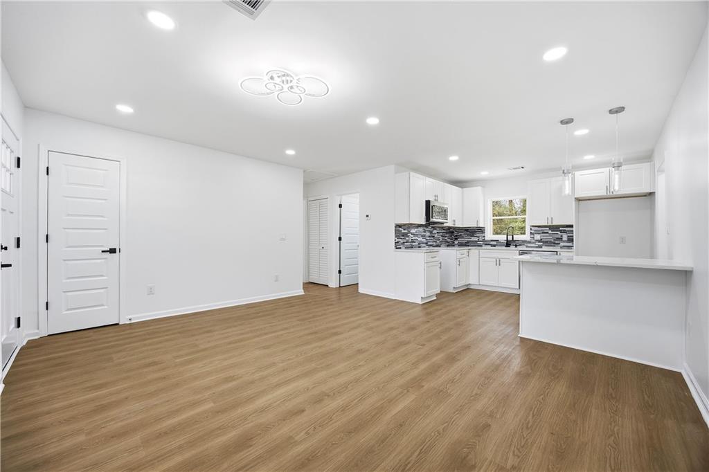 1775 Hadlock Street Southwest Atlanta, GA 30311 - Photo 7 of 27 a view of kitchen with kitchen island a sink wooden floor and stainless steel appliances