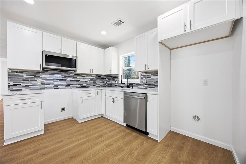 1775 Hadlock Street Southwest Atlanta, GA 30311 - Photo 8 of 27 a kitchen with granite countertop white cabinets and white appliances