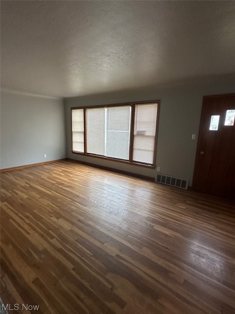 4994 North Barton Road Cleveland, OH 44124 - Photo 2 of 28 Spare room featuring dark hardwood / wood-style floors and a textured ceiling
