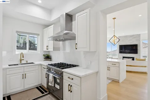 a kitchen with kitchen island granite countertop a refrigerator and a chandelier