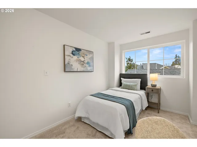 a bedroom with a bed and a painting on the wall