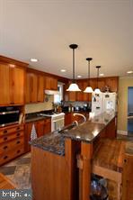 10504 Amherst Avenue Silver Spring, MD 20902 - Photo 2 of 21 a kitchen with stainless steel appliances kitchen island granite countertop a stove and a sink
