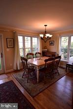 10504 Amherst Avenue Silver Spring, MD 20902 - Photo 8 of 21 a dining room with wooden floor a chandelier a wooden table and chairs