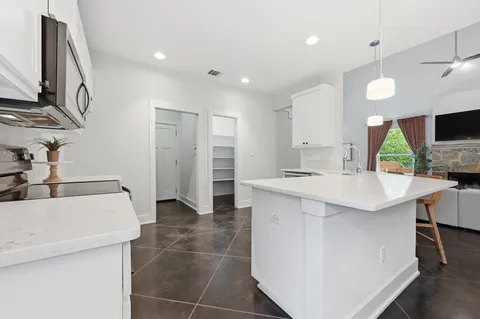 a kitchen with kitchen island a sink stainless steel appliances and cabinets