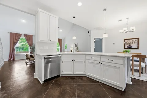 a kitchen with white cabinets and sink