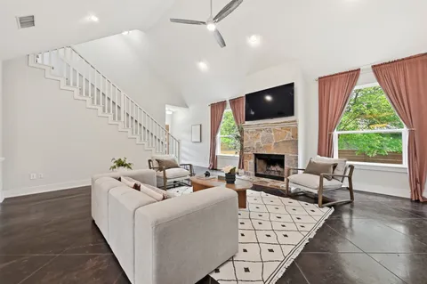 a living room with furniture a fireplace and a flat screen tv