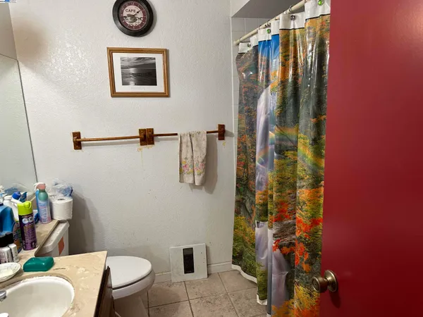 a bathroom with a toilet sink and shower curtain