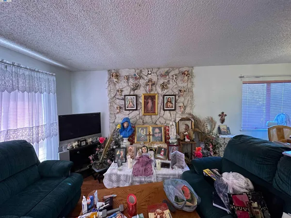 a living room with furniture a flat screen tv and a window