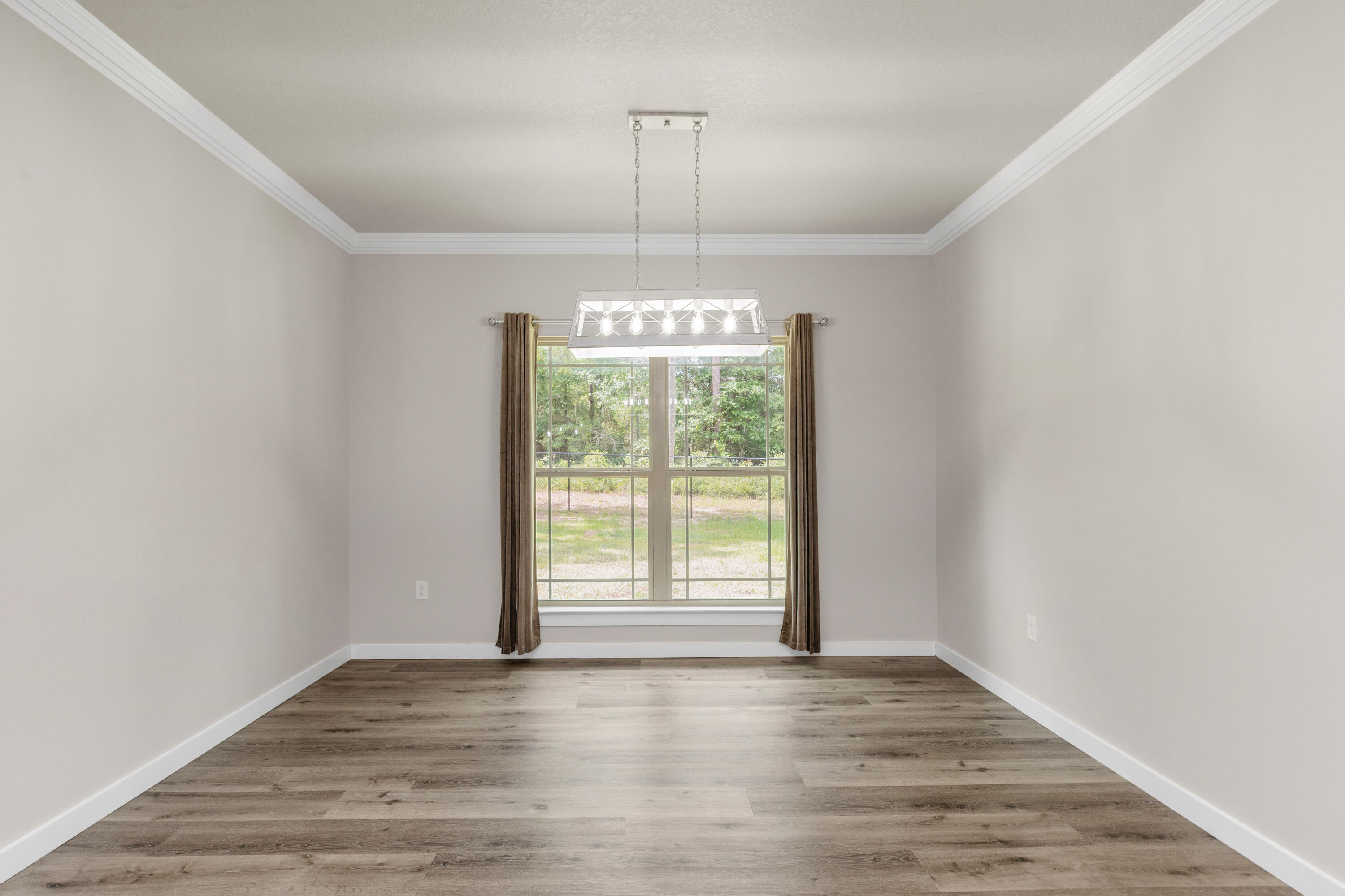 6437 Amanda Court Crestview, FL 32536 - Photo 13 of 48 a view of an empty room with wooden floor and a window