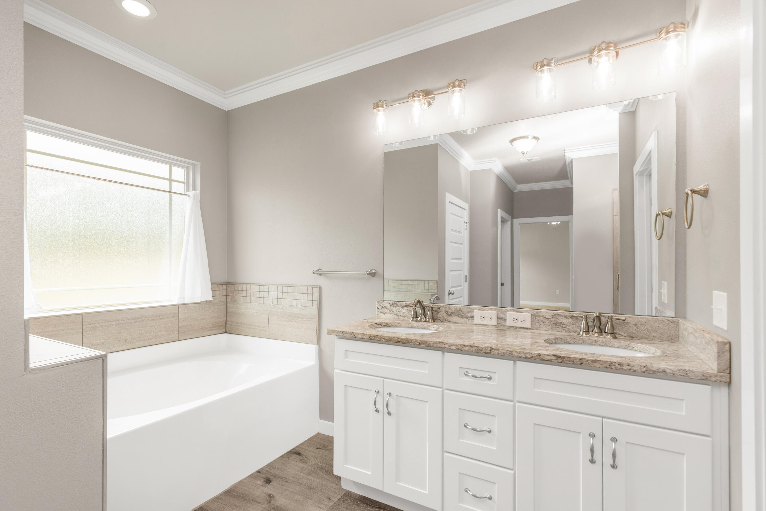 6437 Amanda Court Crestview, FL 32536 - Photo 26 of 48 a bathroom with a tub a sink double vanity and a mirror