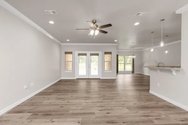 an empty room with windows and ceiling fan
