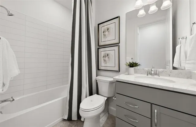 a bathroom with a granite countertop sink a toilet and bathtub