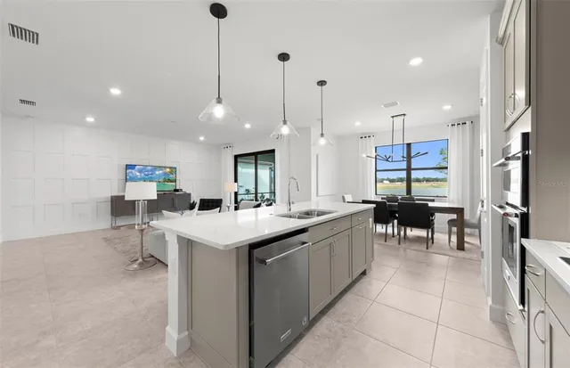 a kitchen with kitchen island a sink table and chairs