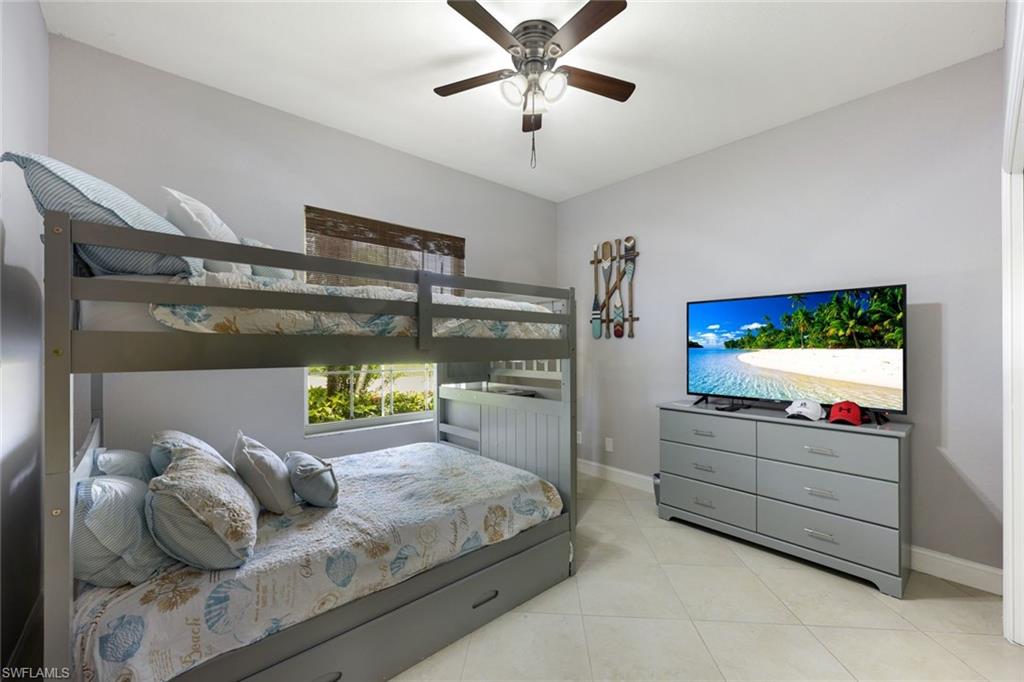 697 Crossfield Circle Naples, FL 34104 - Photo 15 of 18 Bedroom featuring light tile patterned flooring and a ceiling fan