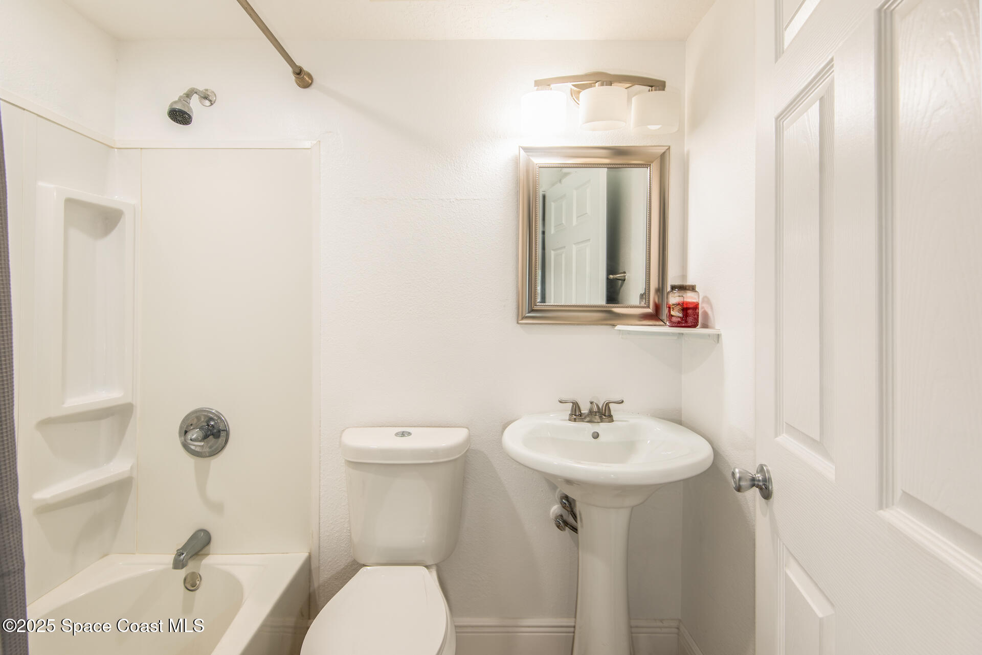 2910 Tropic Road Melbourne, FL 32935 - Photo 12 of 18 a bathroom with a sink a toilet and shower curtain