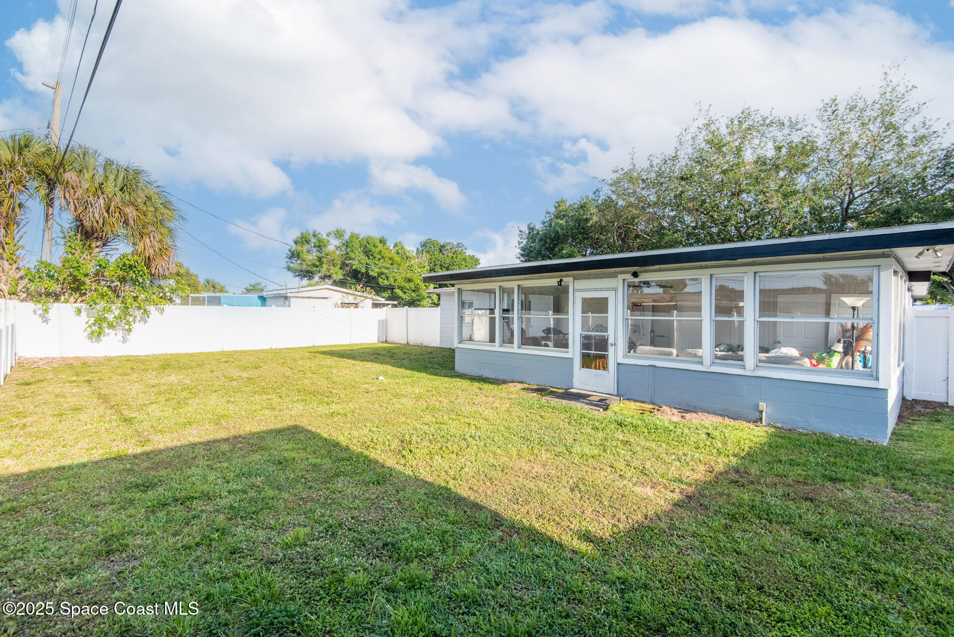 2910 Tropic Road Melbourne, FL 32935 - Photo 16 of 18 a view of a house with pool and a yard