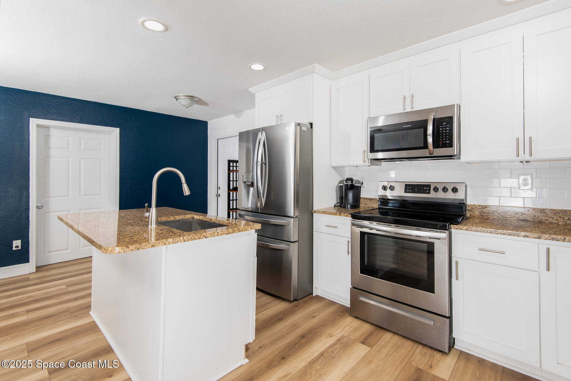 2910 Tropic Road Melbourne, FL 32935 - Photo 6 of 18 a kitchen with stainless steel appliances granite countertop a stove a microwave and a refrigerator