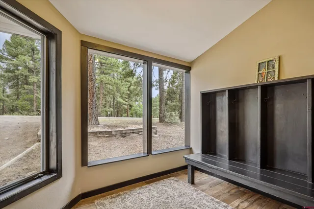 a view of an empty room with wooden floor and windows