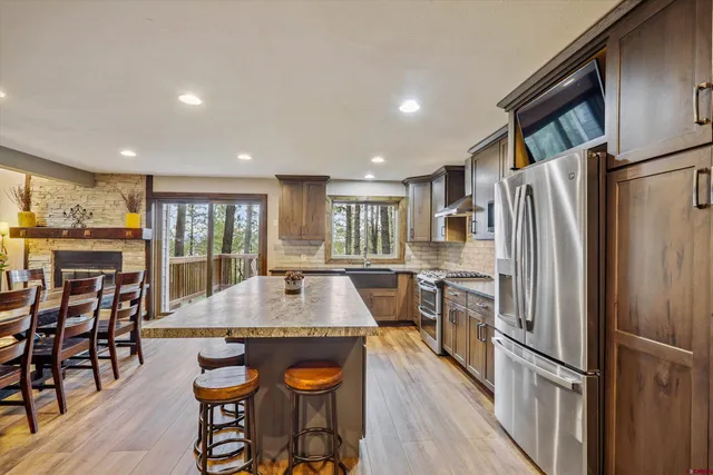 a large kitchen with kitchen island granite countertop a large counter top stainless steel appliances and cabinets
