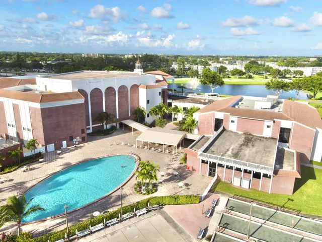 an aerial view of a house with a swimming pool and lake view