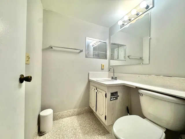 a bathroom with a sink a toilet a mirror and shower
