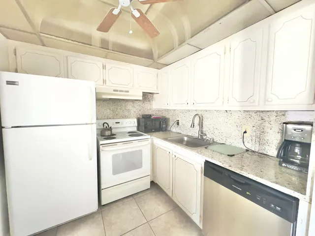 a kitchen with a sink a refrigerator and cabinets