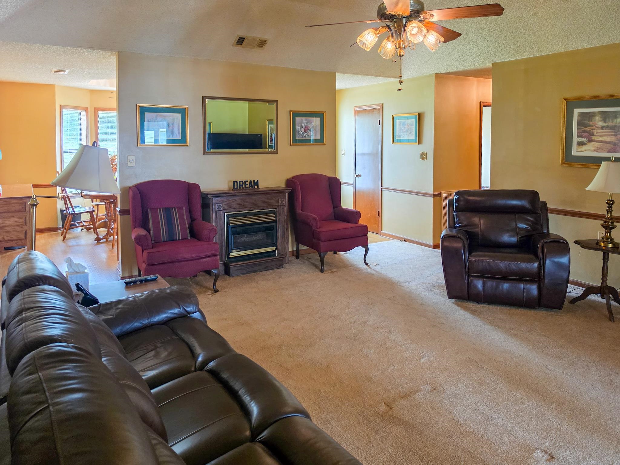 966 Beaver Road Munford, TN 38058 - Photo 9 of 32 Carpeted living area featuring a decorative electric fireplace with a wood-finish mantel and a ceiling fan with integrated lighting