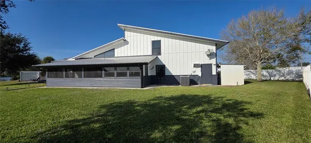 a view of a swimming pool and lounge chairs in back yard of the house