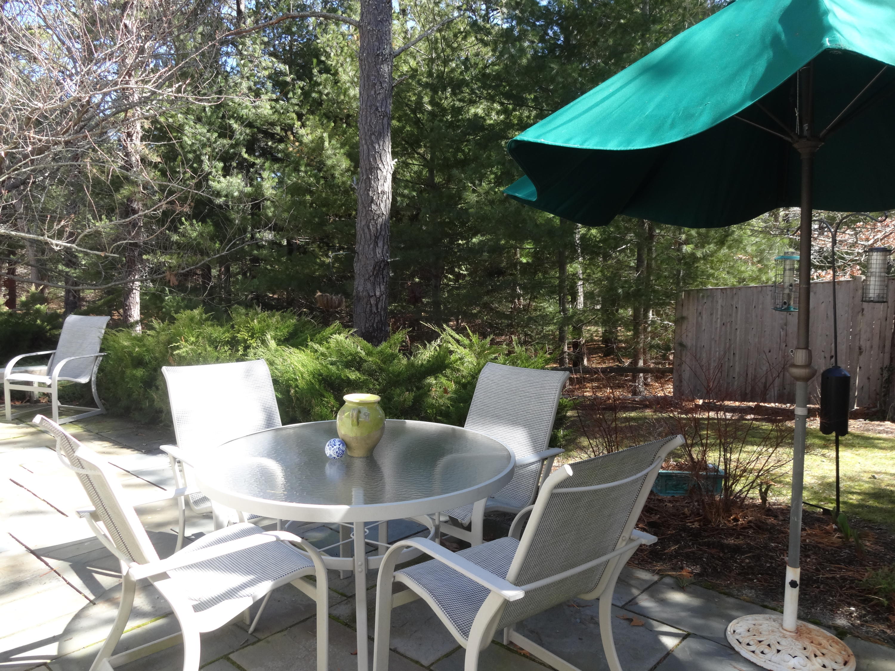 105 Cole Road Eastham, MA 02642 - Photo 12 of 30 a view of a patio with table and chairs under an umbrella