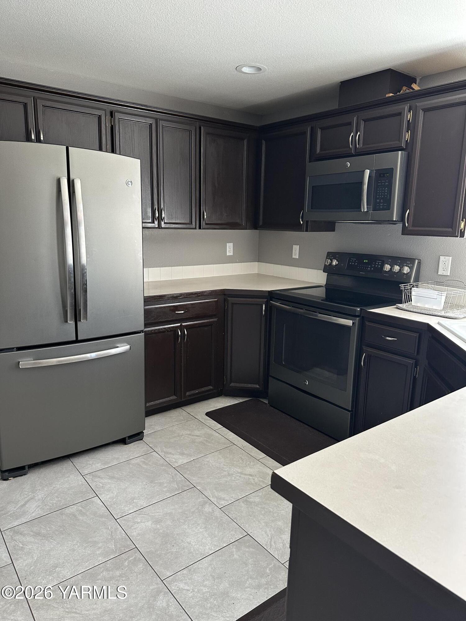 514 Cascade Avenue Moxee, WA 98936 - Photo 24 of 25 a kitchen with stainless steel appliances a sink a stove a refrigerator and cabinets
