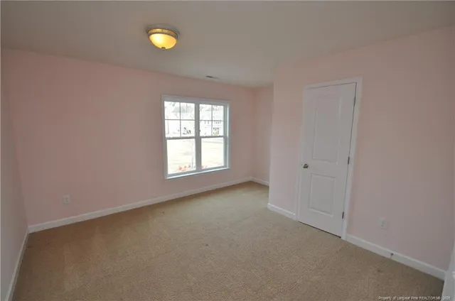 an empty room with windows and mirror