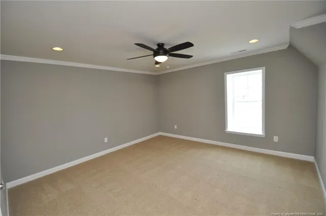 an empty room with a window and a ceiling fan