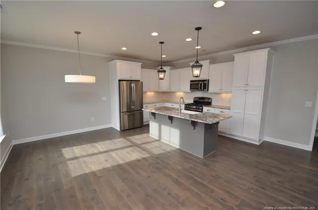 a kitchen with kitchen island a sink stainless steel appliances and cabinets