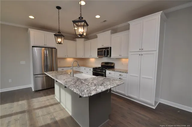 a kitchen with stainless steel appliances granite countertop a sink refrigerator and microwave