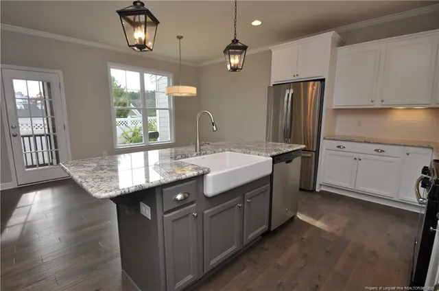 a kitchen with stainless steel appliances granite countertop a sink a stove and a refrigerator