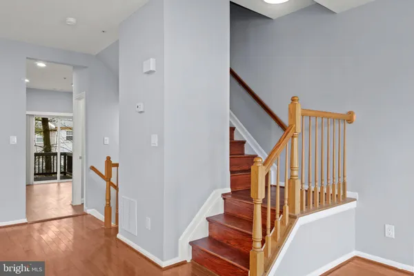 a view of a hallway with wooden floor and staircase