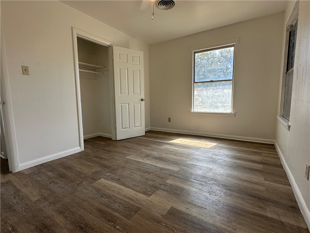 317 Redwood Drive Mathis, TX 78368 - Photo 18 of 26 an empty room with wooden floor and windows