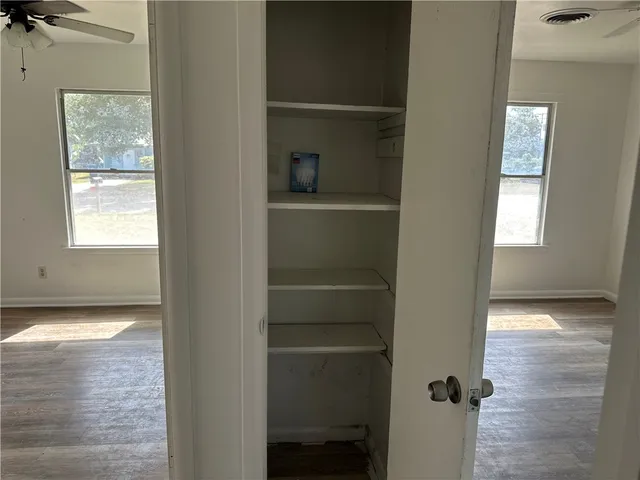 a view of a hallway with closet and window