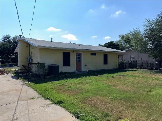 a backyard of a house with table and chairs