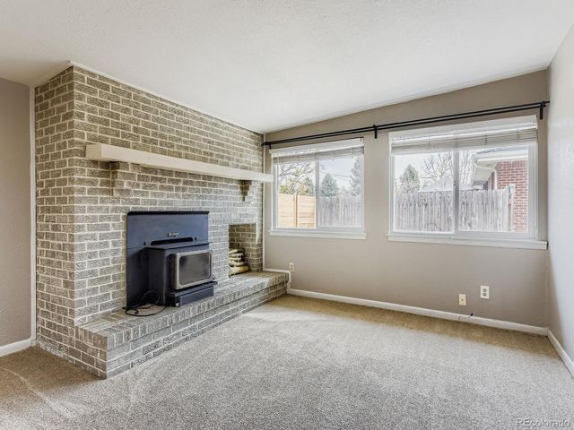 a view of an empty room with a fireplace and a window