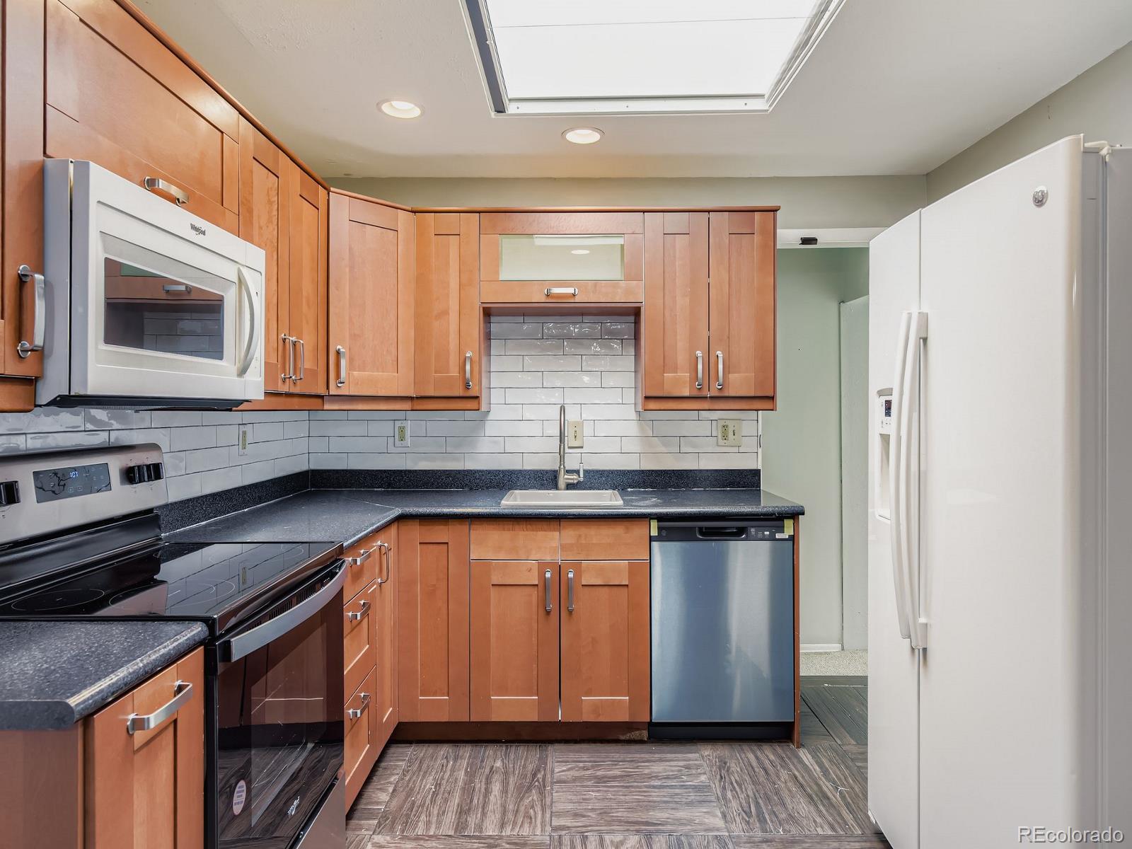 6536 South Kit Carson Street Centennial, CO 80121 - Photo 6 of 32 a kitchen with stainless steel appliances granite countertop a stove a sink and a microwave