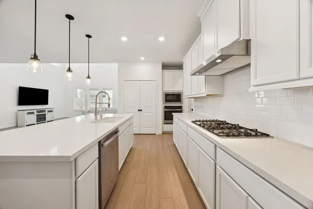 a kitchen with kitchen island a white stove top oven and wooden floor
