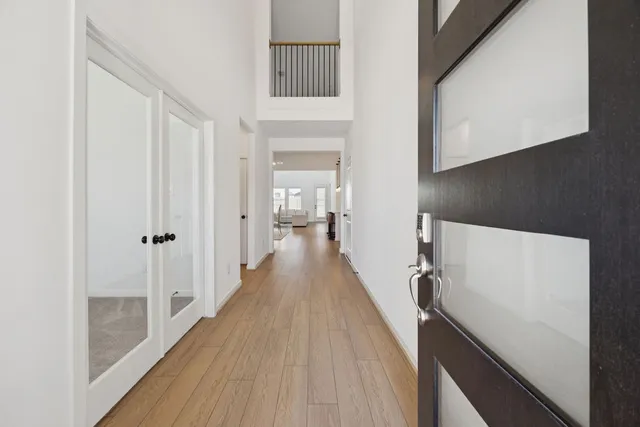 a view of a hallway with wooden floor and staircase