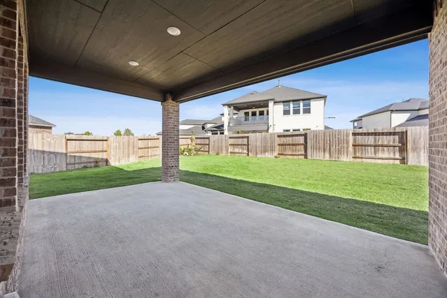 a view of a porch with two chairs and a big yard