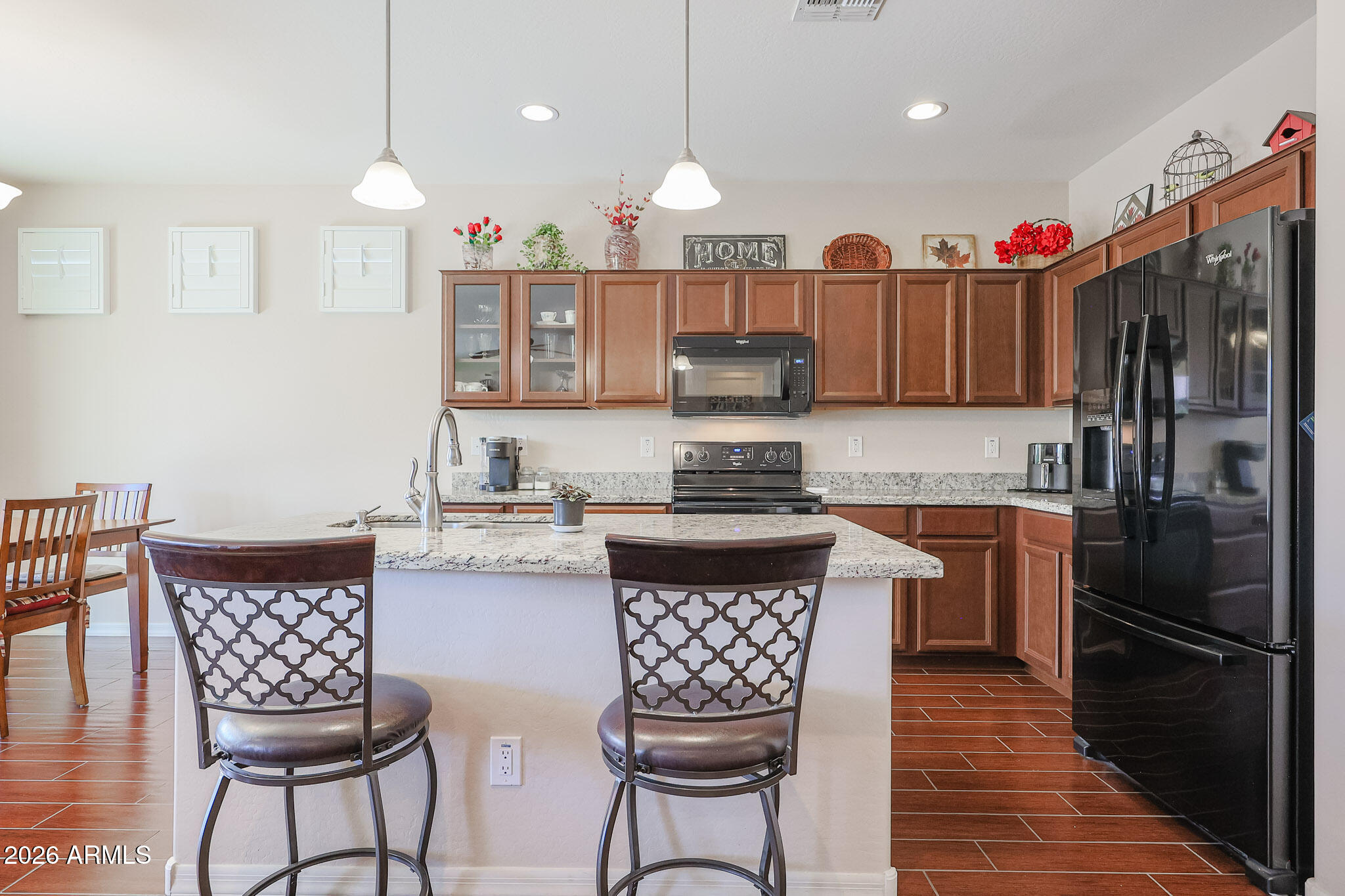 17545 West Fairview Street Goodyear, AZ 85338 - Photo 12 of 55 a kitchen with a refrigerator a stove a sink and chairs