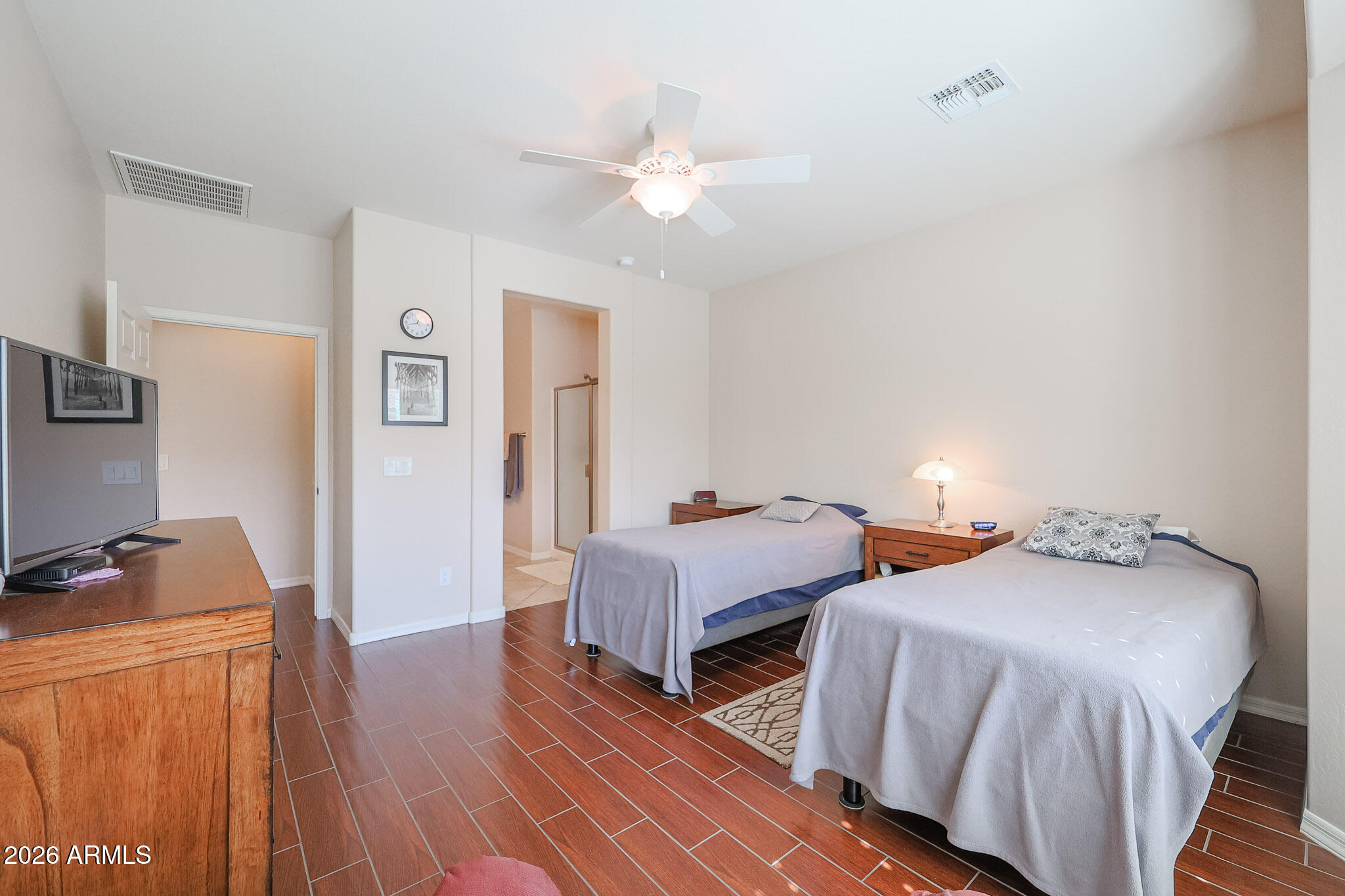 17545 West Fairview Street Goodyear, AZ 85338 - Photo 16 of 55 a bedroom with two beds and a chandelier