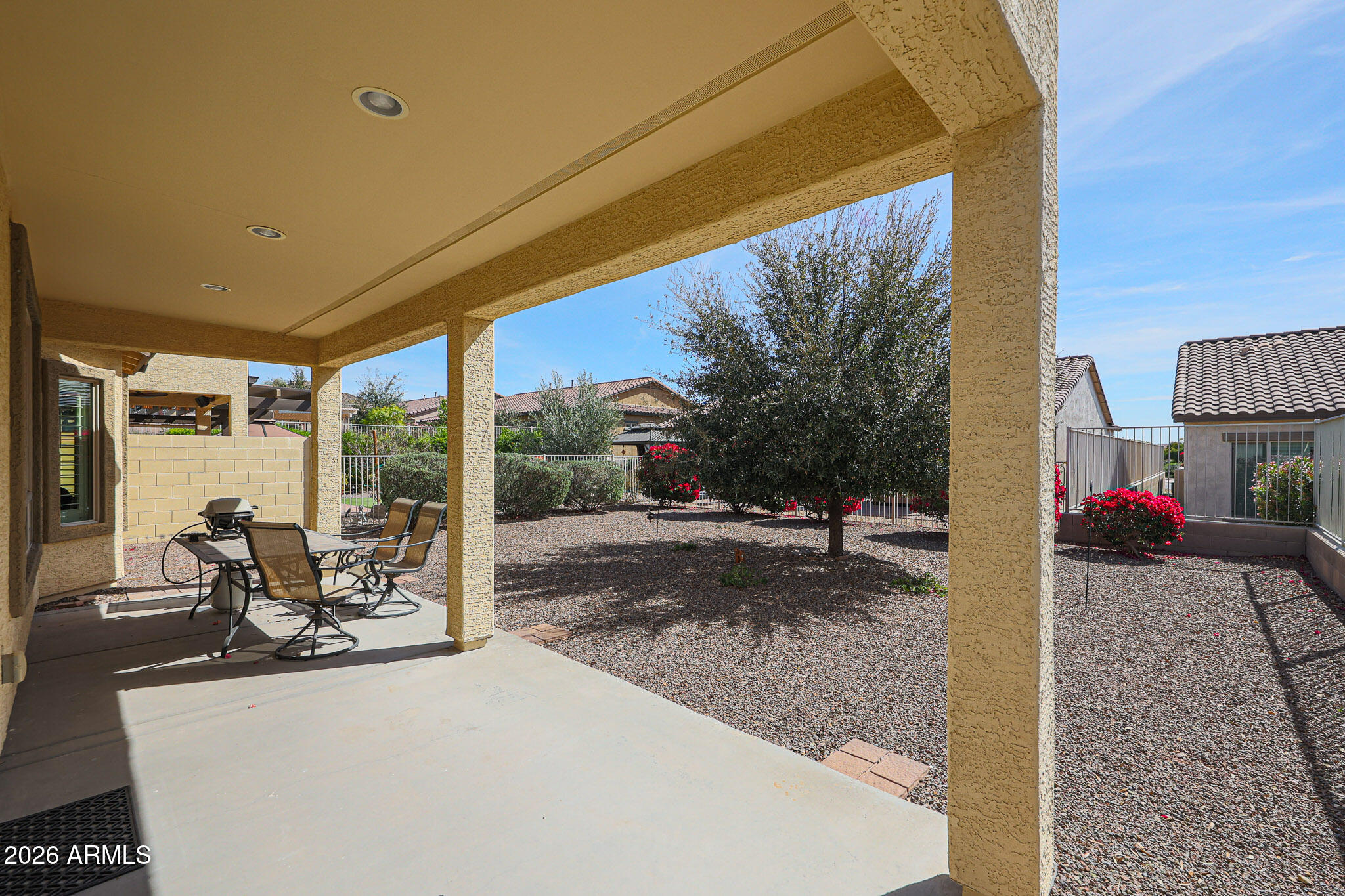 17545 West Fairview Street Goodyear, AZ 85338 - Photo 27 of 55 a view of a patio with a table and chairs and floor to ceiling window