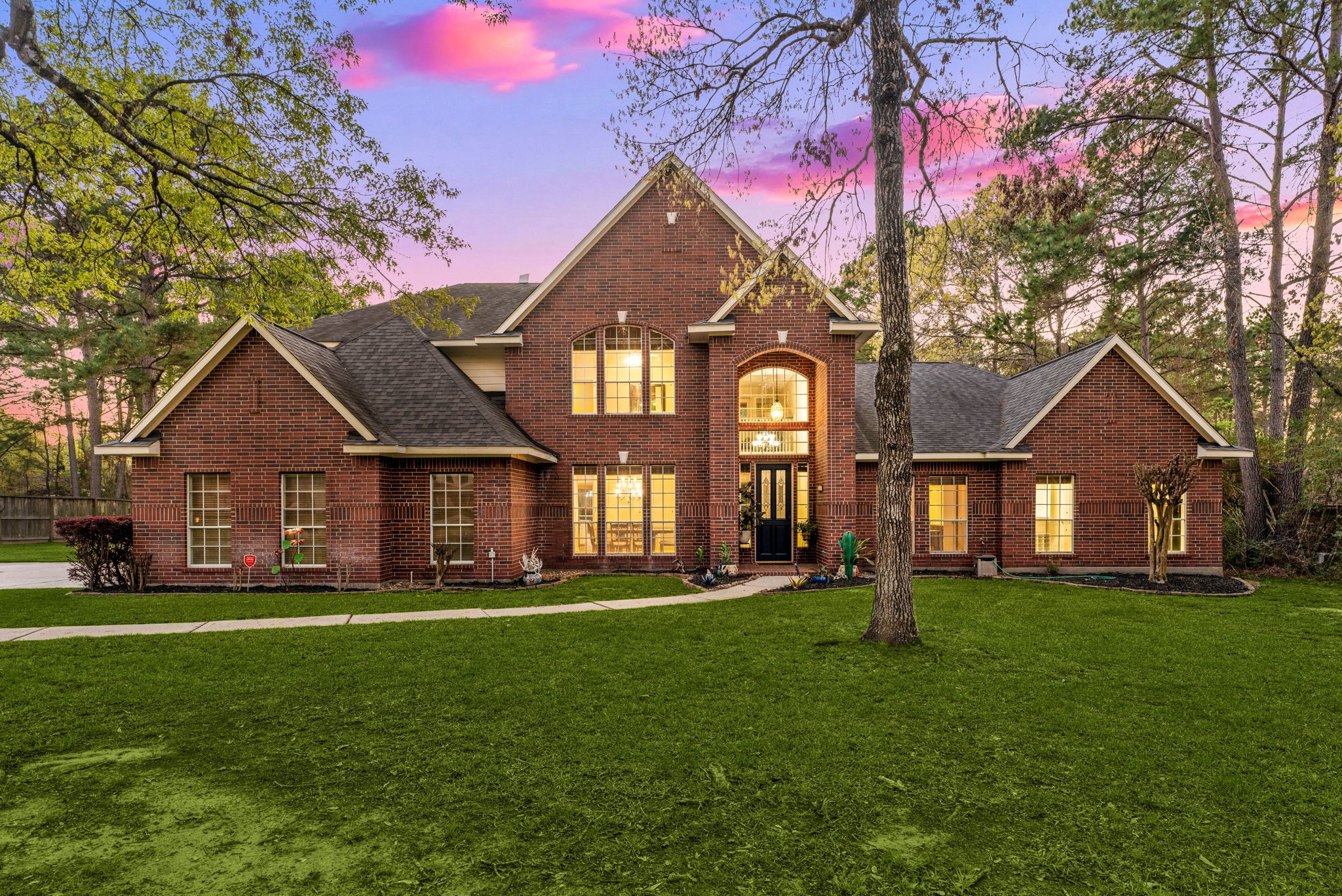 Welcome home to 14419 Timbergreen Drive! This stunning two-story brick home sits on a beautiful oversized lot surrounded by mature trees, offering privacy, charm, and timeless curb appeal. The grand front elevation, manicured lawn, and impressive entry create a warm and elegant first impression.